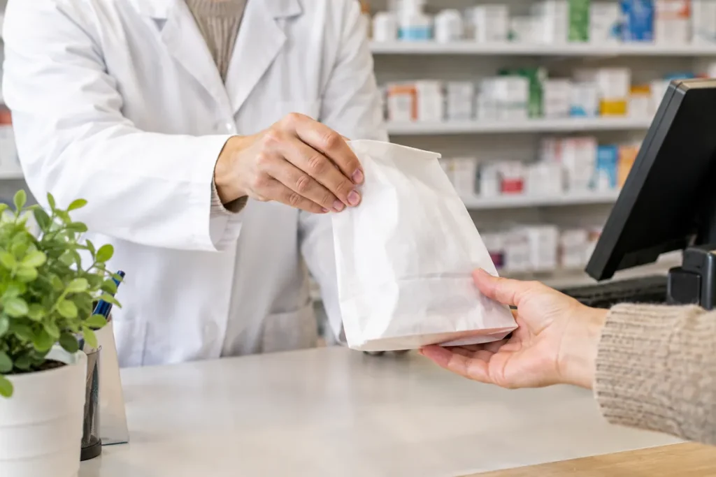 Pharmacie – pharmacien remettant un sachet au comptoir